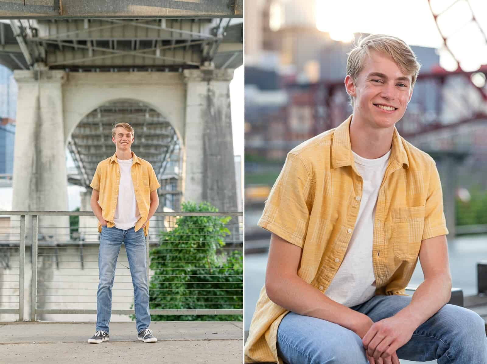 Senior boy in yellow shirt poses under bridge near river